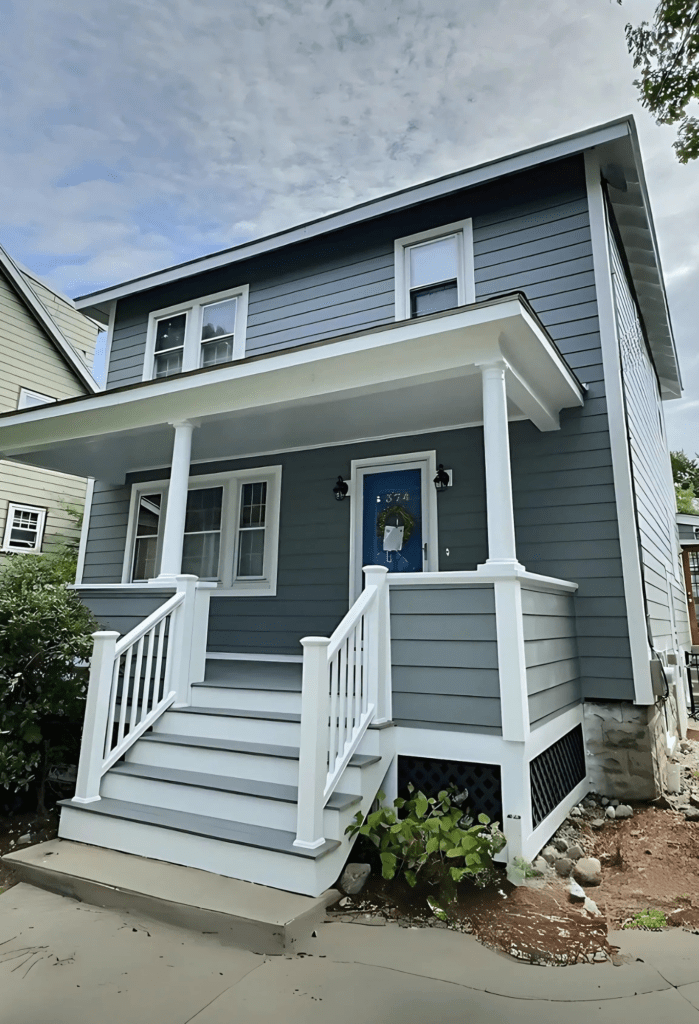 A beautifully renovated home featuring new siding and a porch, showcasing D&G Exteriors’ expert home improvement process in Malden, MA.