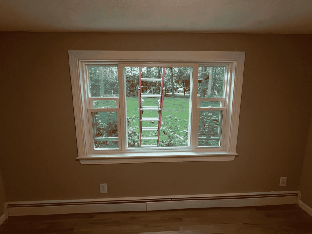 A newly installed large window with white framing, enhancing natural light and insulation in a modern home.