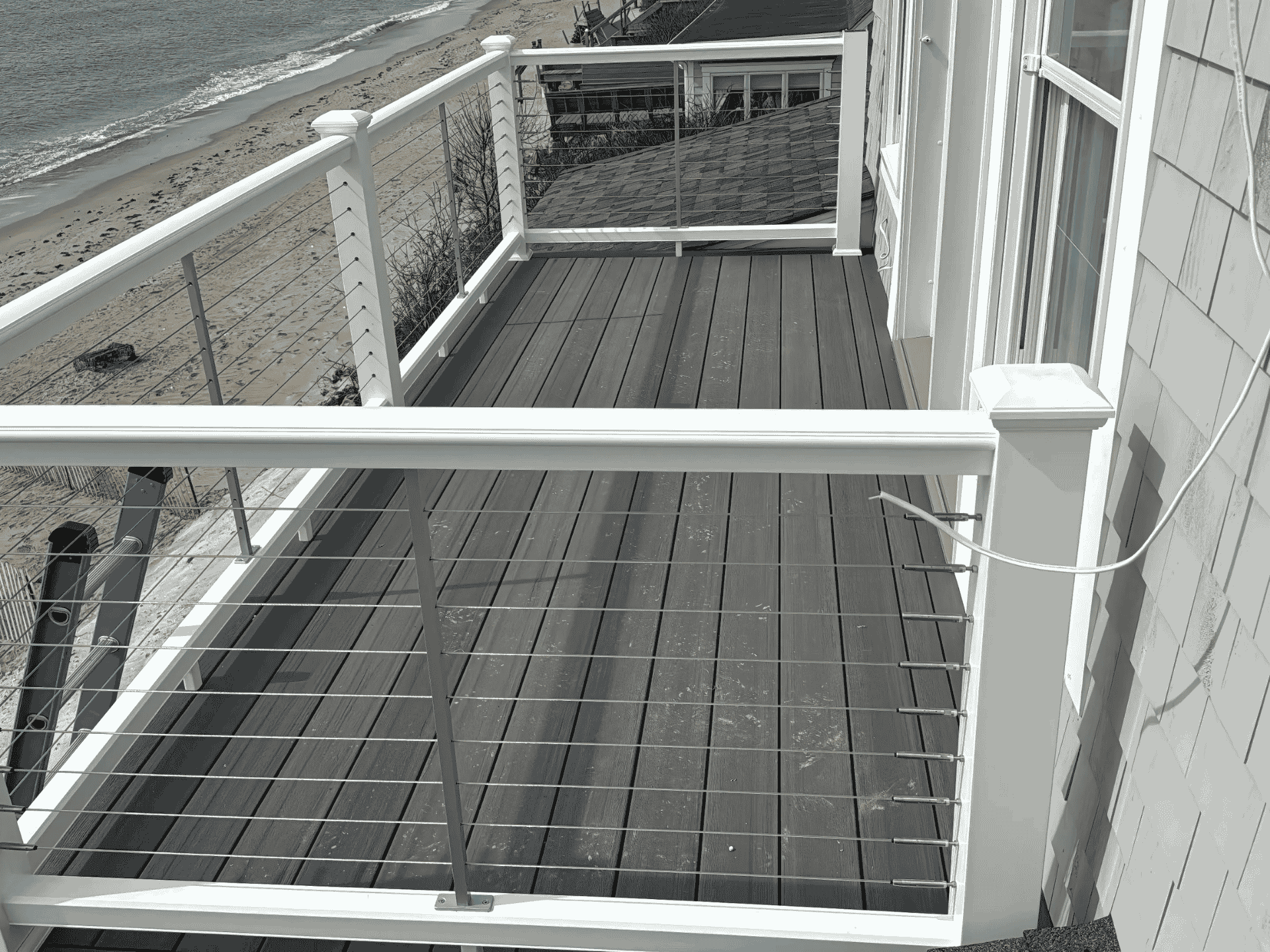 A stylish beachfront deck with cable railings installed by D&G Exteriors in Salem, MA.