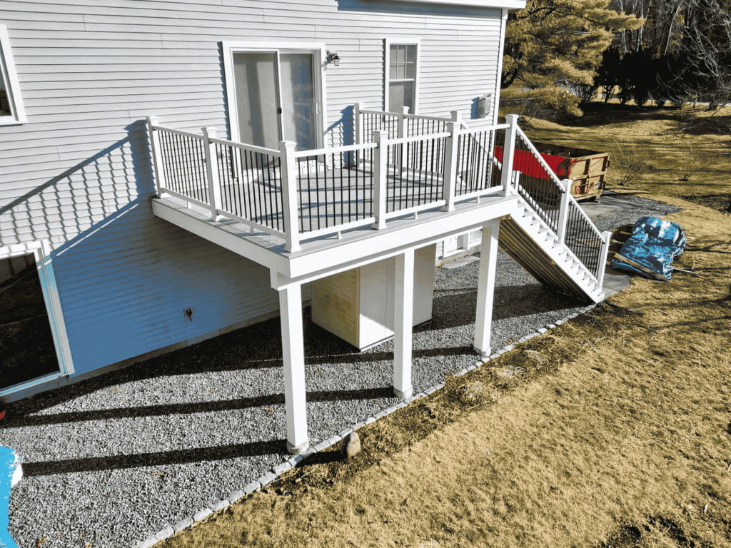 A raised deck with white railings and wooden flooring, providing a stylish outdoor living space in Marblehead, MA.