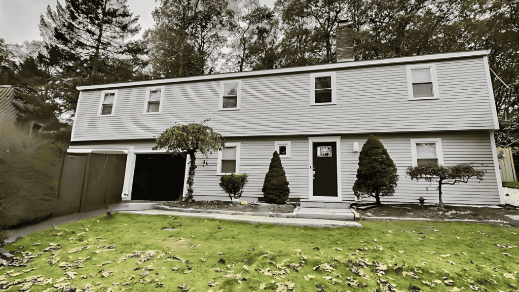 A two-story house with fresh siding and a well-maintained lawn in Malden, MA.