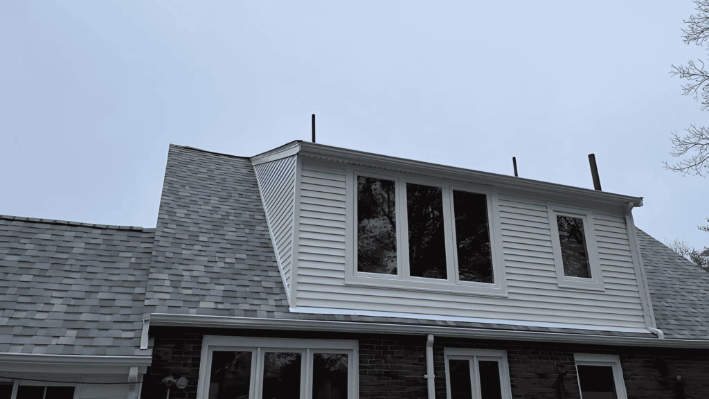 A close-up of a home’s newly installed dormer windows with white trim in Malden, MA.