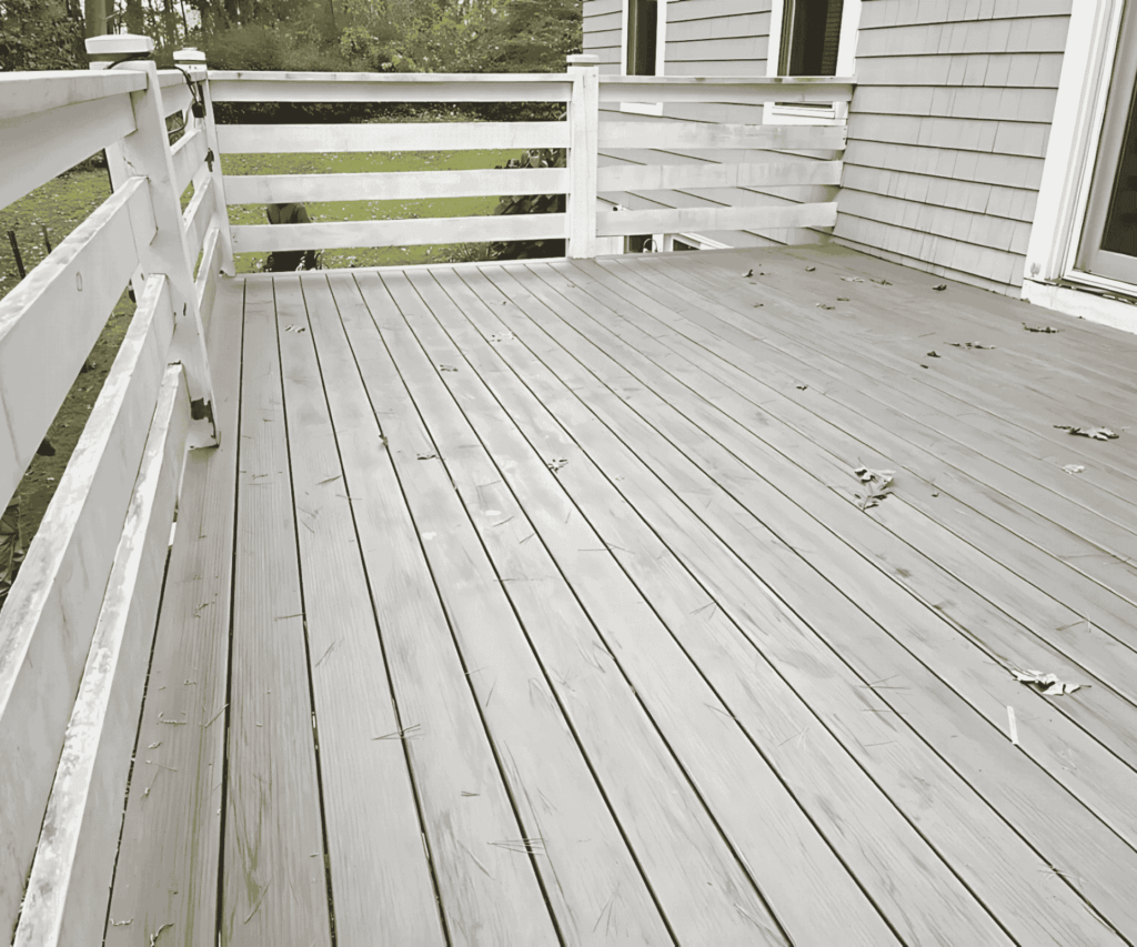 A newly constructed outdoor deck with a sturdy railing in Medford, MA by D&G Exteriors.